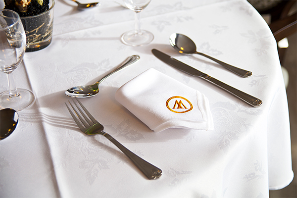 place setting with embroidered Manor Grange napkin