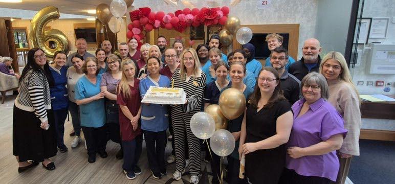 Care Home Team celebrate outstanding inspection rating with cake and balloons
