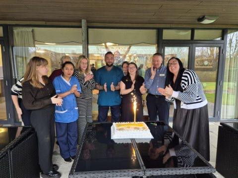 The Manor Grange Care Home team celebrating recent inspection results with cake