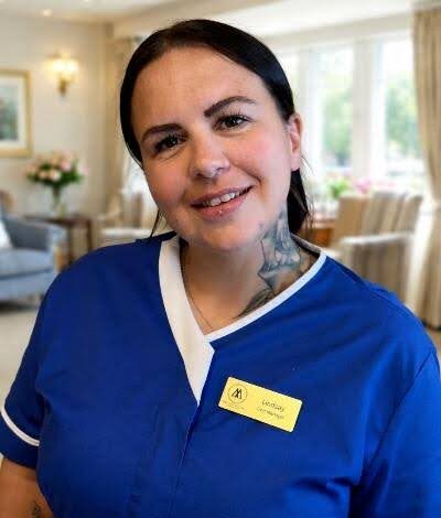 woman with dark hair smiling in a blue uniform