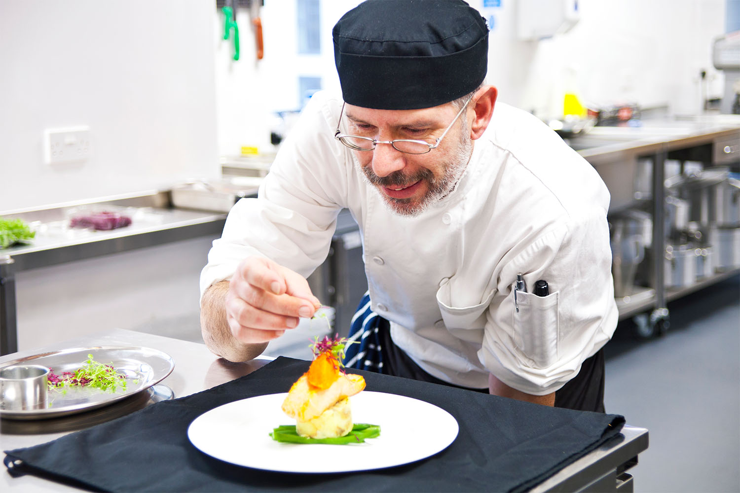 manor grange chef putting garnish on salmon dish
