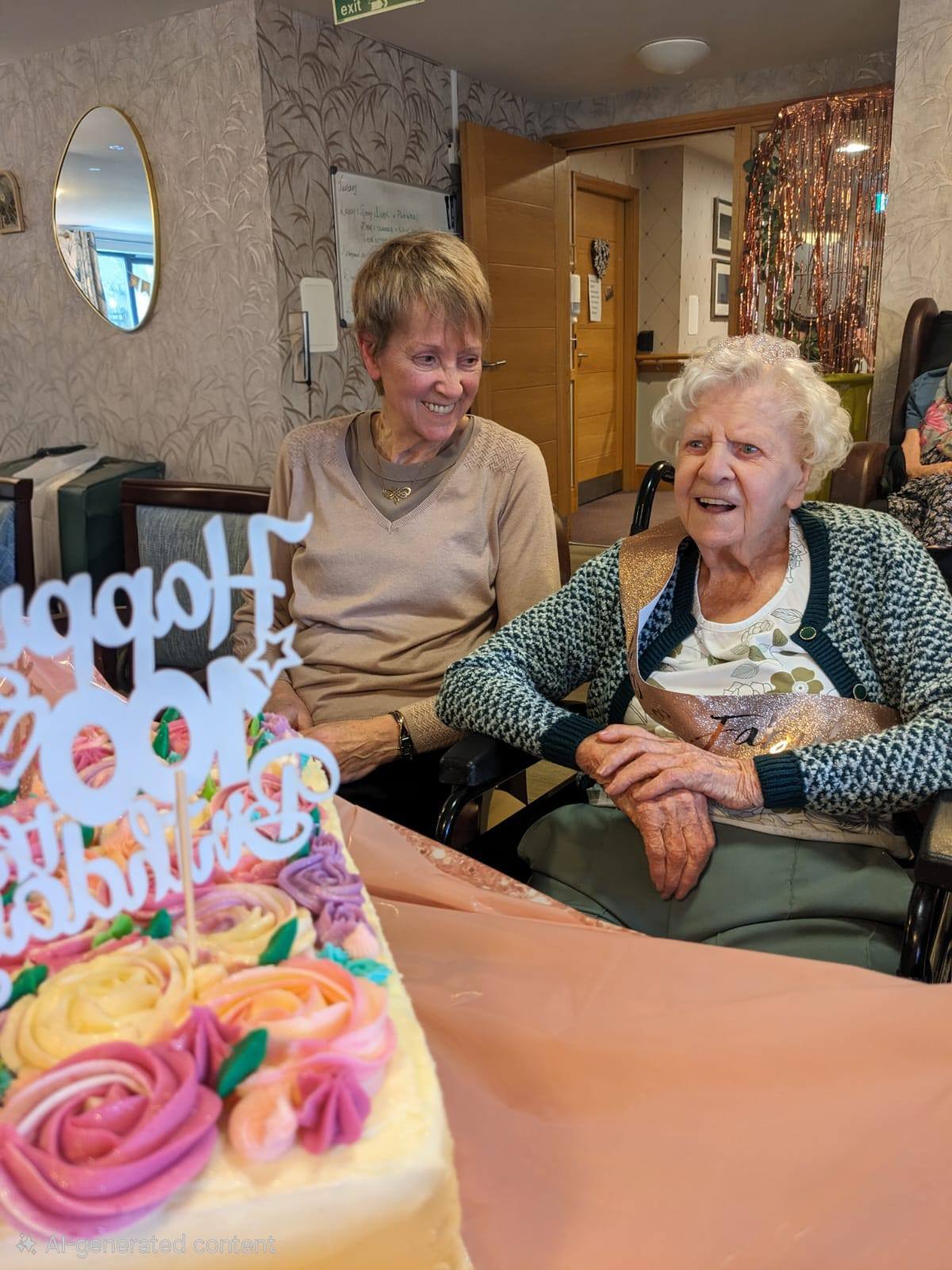 two ladies sat down smiling at a birthday celebration