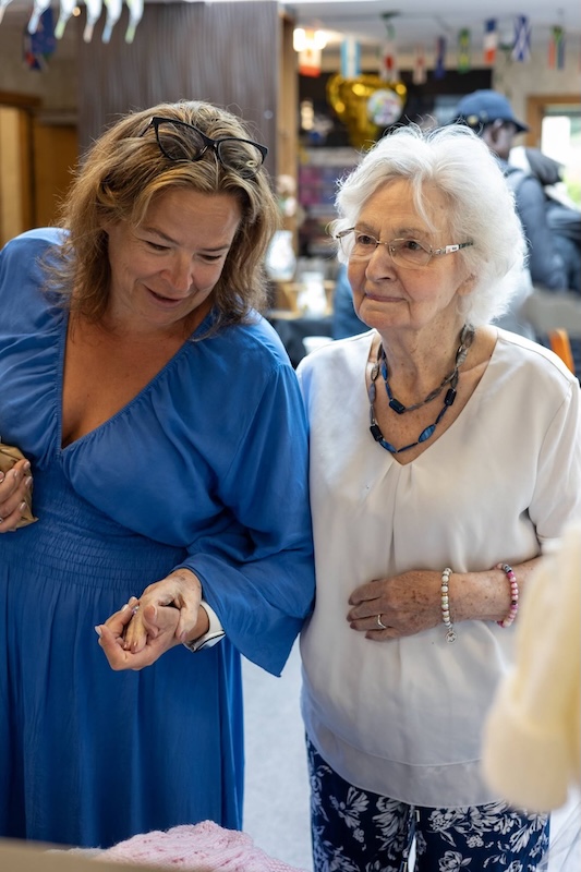 Woman holding hand of elderly woman at market