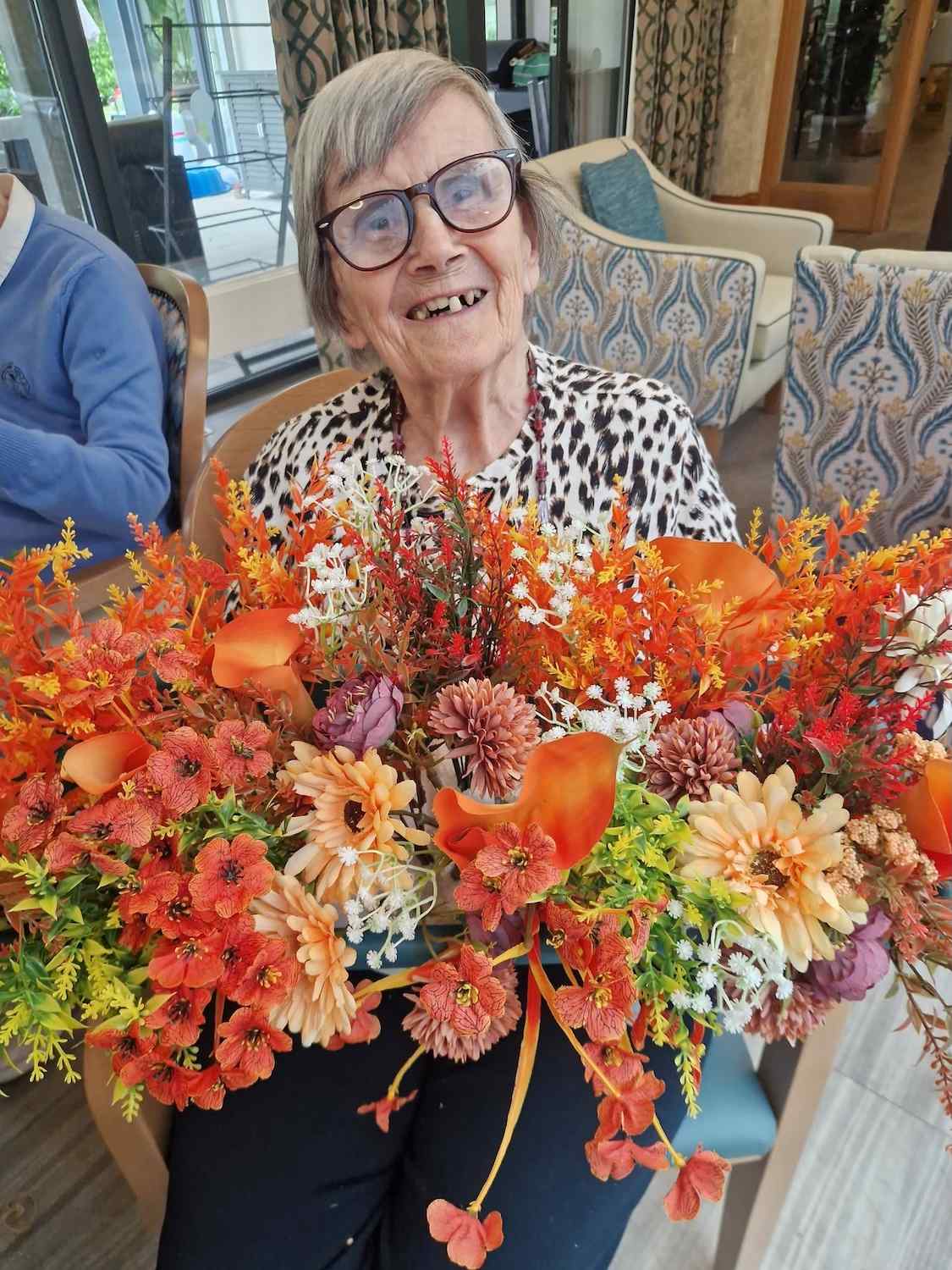 Woman smiling holding bouquet of orange flowers