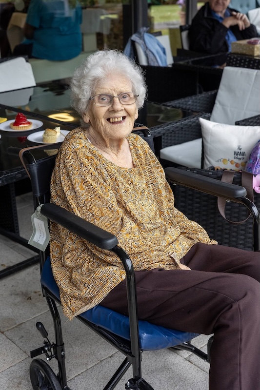 Elderly woman in wheelchair smiles